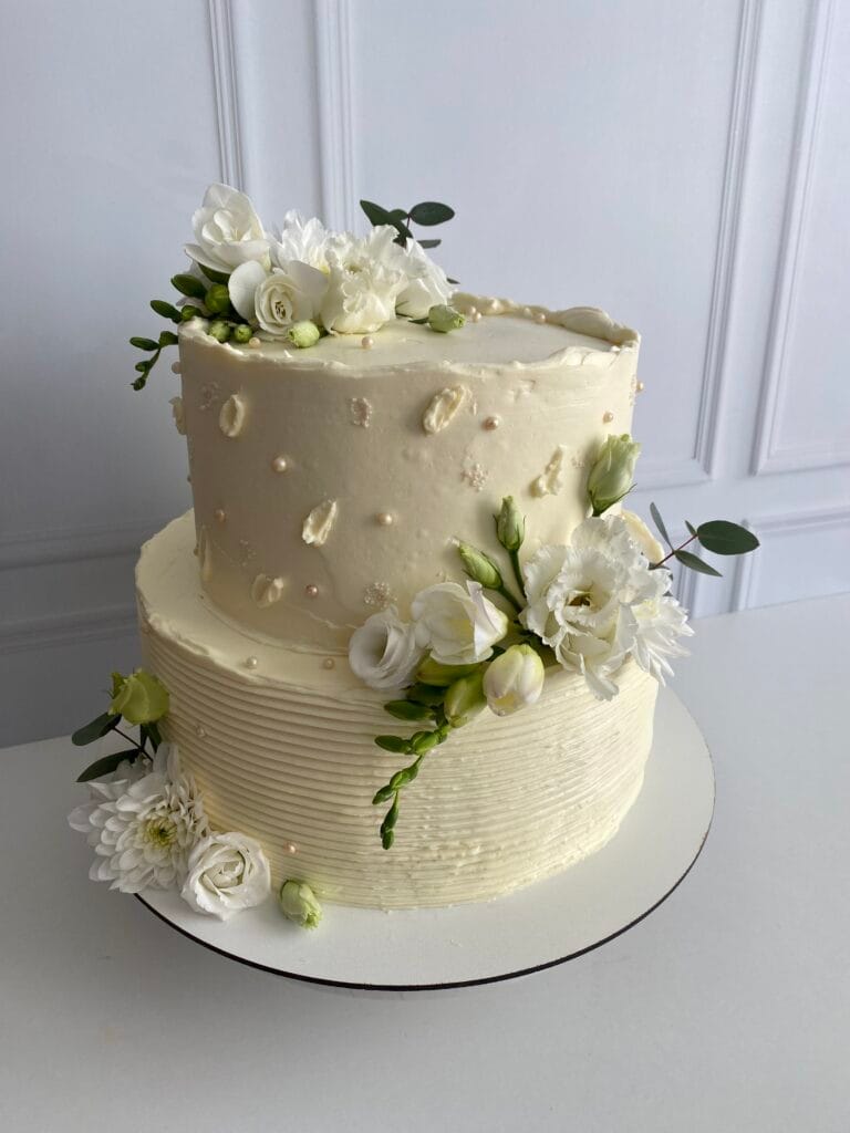 Elegantná dvojposchodová krémová svadobná torta zdobená kvetmi od LE BON - Považská Bystrica.