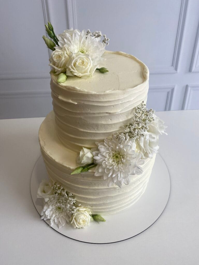 Elegantná dvojposchodová krémová svadobná torta zdobená kvetmi od LE BON - Považská Bystrica.
