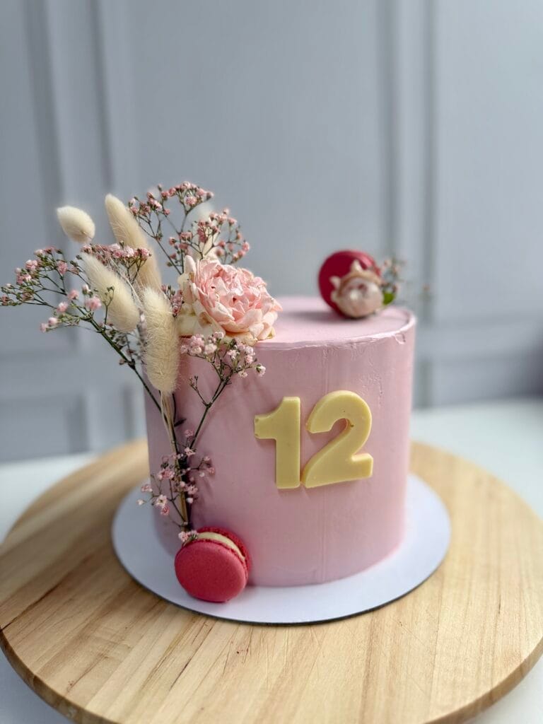 Elegantná jednoposchodová krémová narodeninová torta pre deti zdobená poľnými kvetmi a makrónkami od LE BON - Považská Bystrica.