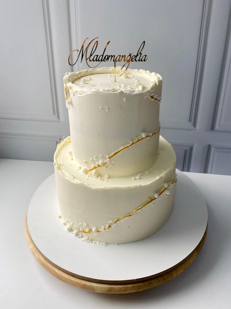 Elegantná dvojposchodová krémová svadobná torta zdobená perlami na zlatom detaile od LE BON - Považská Bystrica.