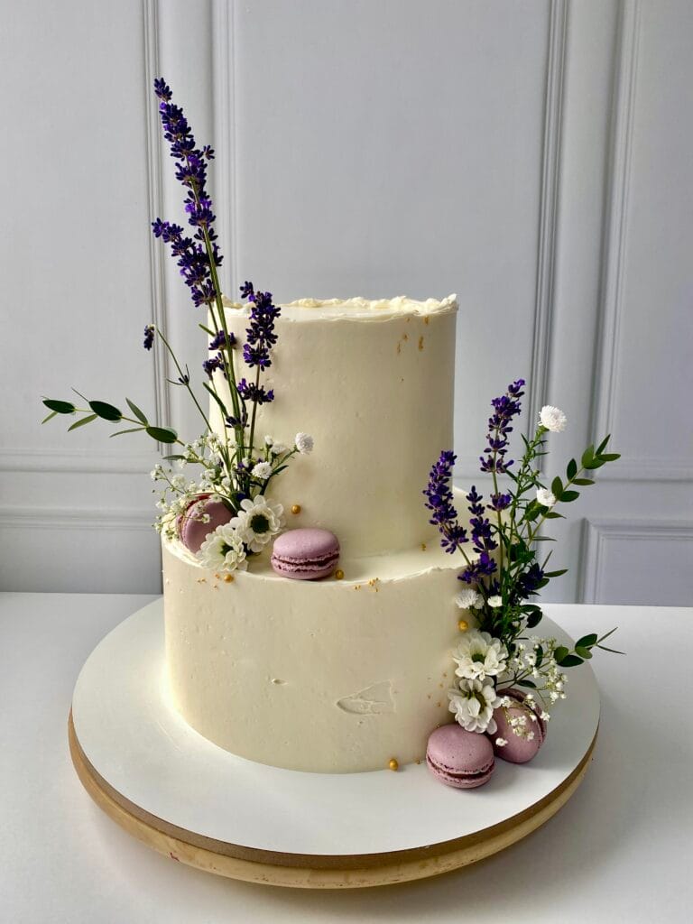 Elegantná dvojposchodová krémová svadobná torta zdobená makrónkami, levanduľou a poľnými kvetmi od LE BON - Považská Bystrica.